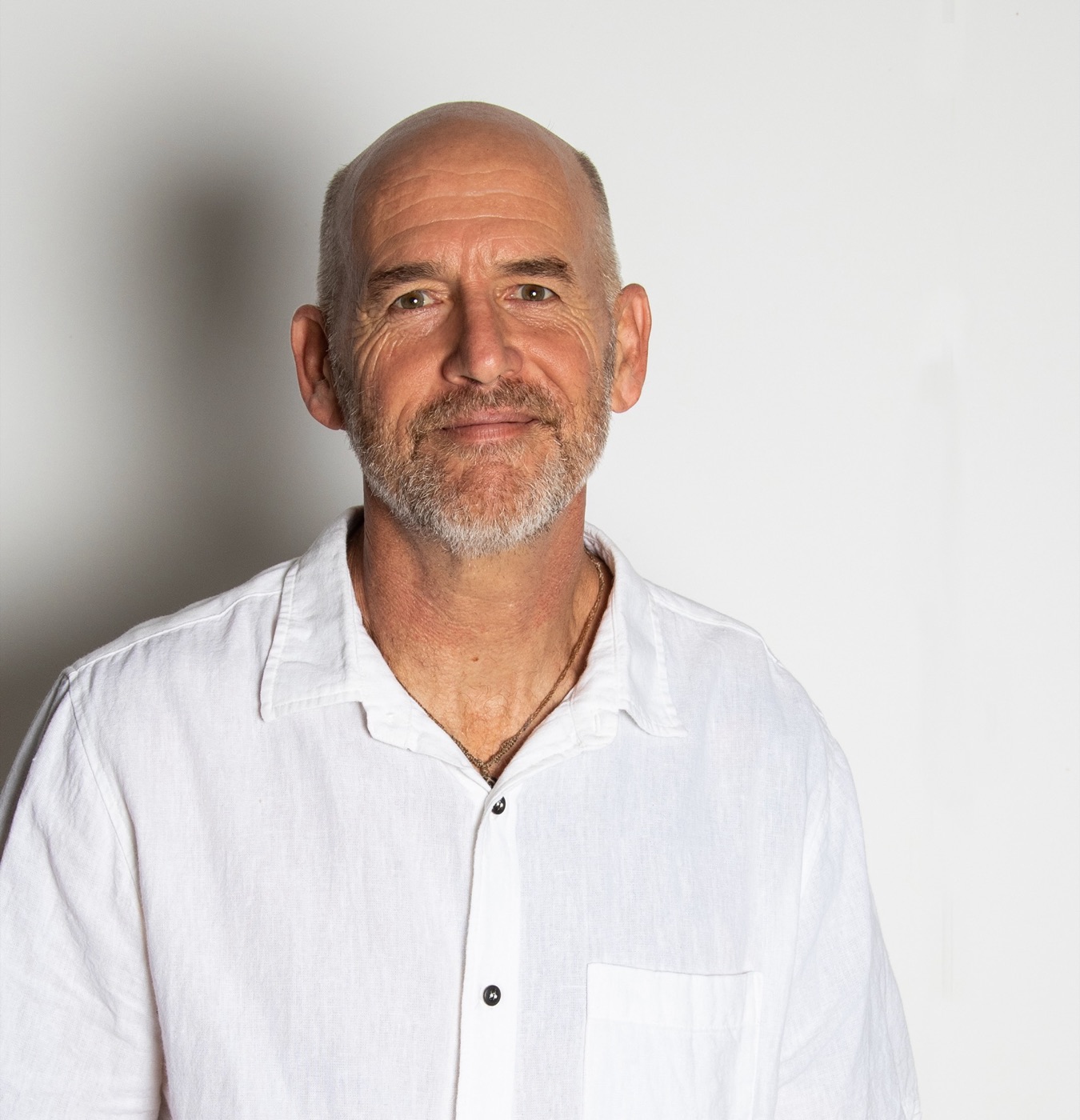 Ed Surman, smiling, in a white linen shirt